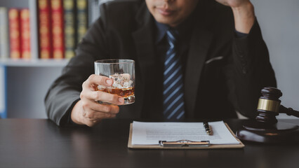 A lawyer holding a glass of whiskey, He's in his office, and he's stressing about arguing for a client, he's a lawyer. The concept of clear legal litigation.