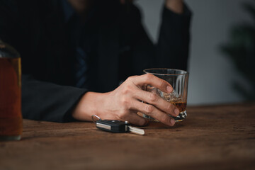 Man holding a glass of brandy, he is drinking brandy in a bar, drinking alcohol impairs driving ability and can damage health. The concept of drinking alcohol.