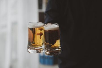 Man holding a glass of brandy, he is drinking brandy in a bar, drinking alcohol impairs driving ability and can damage health. The concept of drinking alcohol.