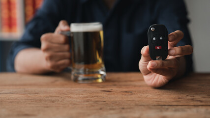 Man holding a glass of brandy, he is drinking brandy in a bar, drinking alcohol impairs driving ability and can damage health. The concept of drinking alcohol.