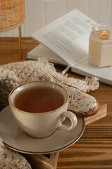 A cup of warm delicious tea on a saucer with a wooden background