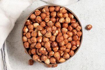 Raw hazelnuts on a gray background. Nuts in a coconut bowl. Top view