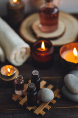 Concept of natural essential organic oils, Bali spa, beauty treatment, relax time. Atmosphere of relaxation, pleasure. Candles, towels, dark wooden background. Alternative oriental medicine