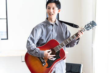 ギターを聞く若い日本人男性