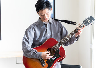 ギターを聞く若い日本人男性