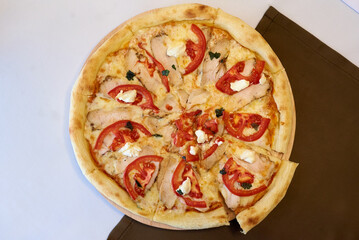 pizza Margarita, top view on a white tablecloth