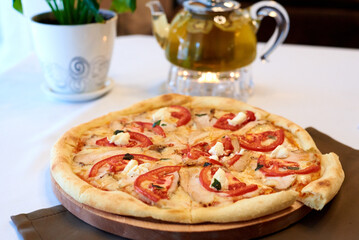 pizza Margarita, with tea on the background