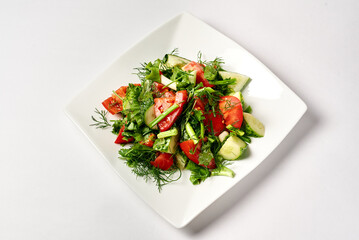 fresh salad in a white plate on a white background