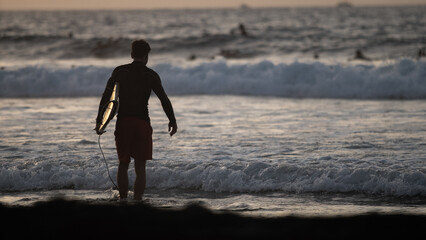 Surfer looking at the ocean ready to hit the perfect wave thanks to his surfboard. We are in Tenerife (Canary Islands).