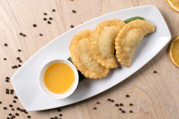 chebureks with sauce on a white plate