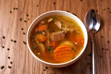shurpa soup, in a white plate on a wooden background