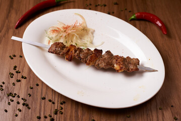 skewers of lamb on a white plate
