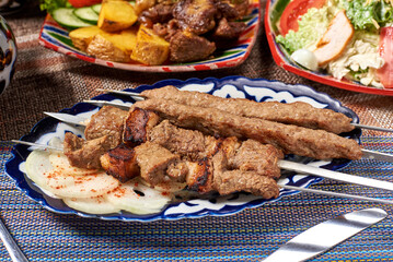 two types of kebabs put on a skewer with onions