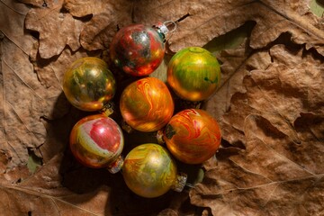 Winter mood- toys for decorating the Christmas tree on a background of oak leaves