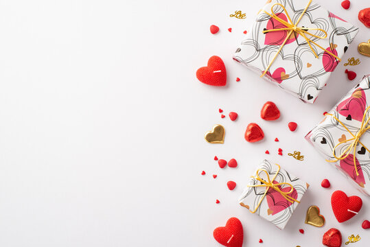 Valentine's Day concept. Top view photo of gift boxes heart shaped candies sprinkles candles and golden confetti on isolated white background with copyspace