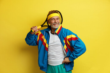 Smiling Man Holding Tennis Rocket. Funny Senior Tennis Player Posing Isolated On Yellow Studio...