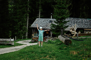 Boy stand against wooden house at Vorderer Gosausee, Gosau, Upper Austria.