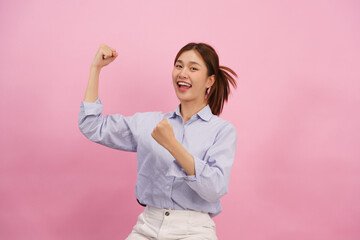 Women are smiling and doing clenching fists up with winner gesture isolated on pink background