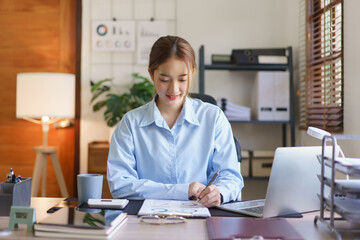 Startup business concept, Businesswomen reading finance data and writing in document at workplace