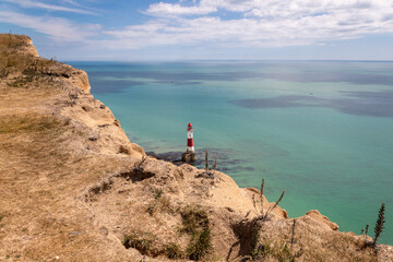 Photographie de paysage du phare de Beachy Head, d'une mer verte émeraude et des falaises des...