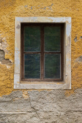 Old wooden window. Around the window is the plaster of the old house.