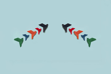 Fototapeta na wymiar banner two groups of five paper origami pigeons lack, red, orange, blue and green fly up on light background