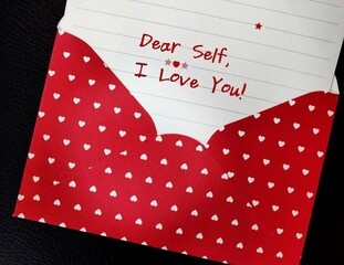 Red heart envelope with handwritten card DEAR SELF, I LOVE YOU - concept of single person writing...