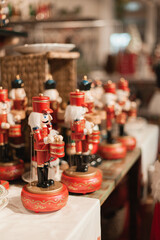 Nutcracker wooden toys army at Christmas market closeup. Winter holiday festive home decor. Handmade souvenir gift shop or store. Nutcrackers army on the shop window.