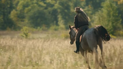 Female rider at the equestrian farm, surrounded with lush, green flora. Caucasian, blonde-hair woman galloping and practicing riding along the countryside ranch. High quality 4k footage