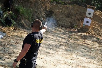 Trening strzelania z broni palnej przez policje i wojsko na strzelnicy sportowej do tarczy. 