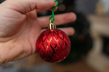hanging a red Christmas ball ornament decoration