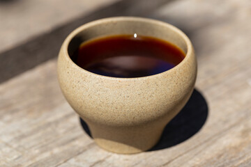 White terracotta cup with oolong tea close-up.