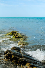 waves splashes on rock in sea shore, pretty calm sea. High quality photo