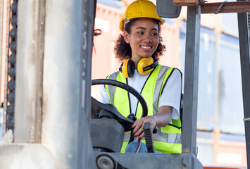 Young female foreman employee driving forklift at shipping container yard, portrait. Afro...