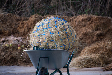 Horse  hay  net  on a  wheel barrow  at stables 