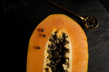 Ripe and freshly cut papaya. Fresh and tropical fruit with dark background