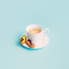 Retro porcelain cup of coffee with fresh French pastry, pastel blue background. 
