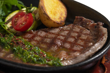 close-up of cooked steak with potatoes and vegetables