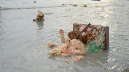 Ganesh Visarjan - Lord Ganesha Idol Immersed In Shallow Beach Water Of Girgaon Chowpatty In Mumbai, India. closeup