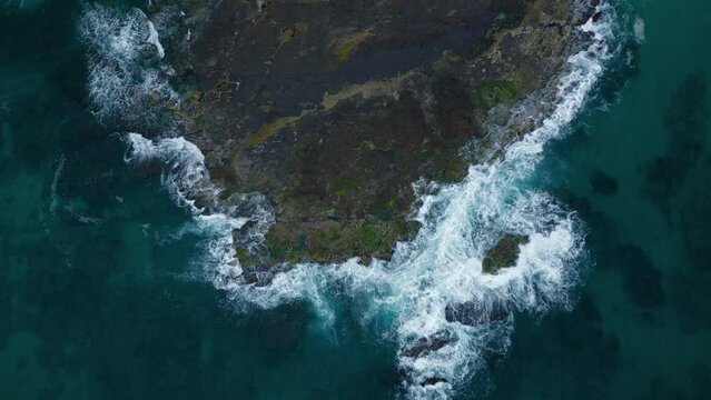 Cinematic rock cliff beach waves seaside nature at Wollongong Sydney. Beautiful aerial drone cinemagraph seamless video loop. Clear blue water waves white sand and palm trees. Scenic vibrant adventure