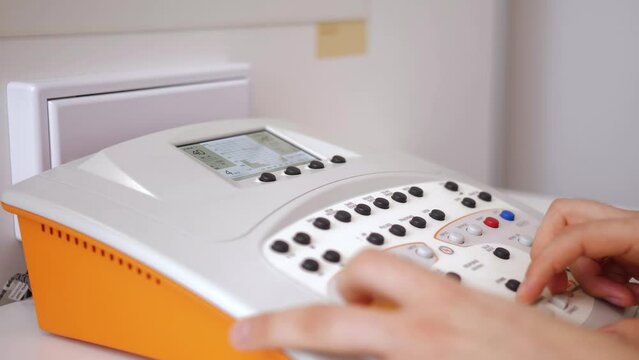 Prosthetist trying to measure using audiometry machine