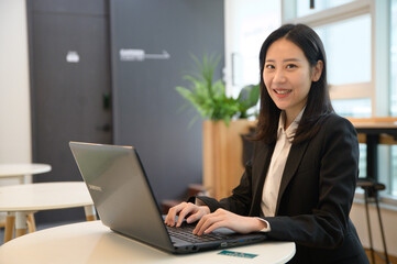 Portrait of successful asian young businesswoman working in her office
