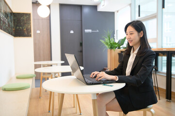 Portrait of successful asian young businesswoman working in her office