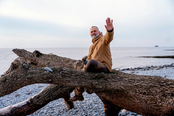 Bearded Man relaxing alone on the seaside on cold winter day. Travel  Lifestyle concept