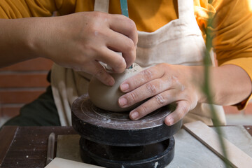 Young Asian Female focusing on her job at the pottery workshop 