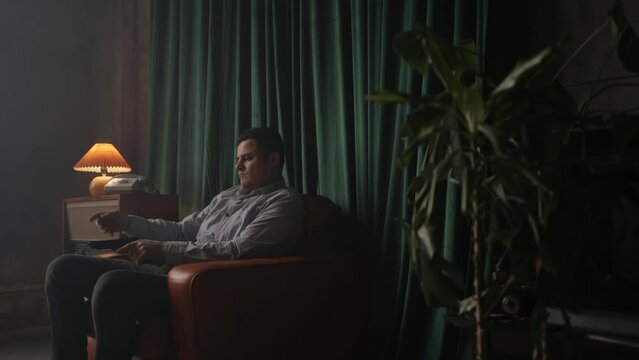 Special secret agent sitting in vintage brown leather armchair with pistol or gun. Spying or intelligence gathering. Espionage concept. Report information to superiors. Cold war.