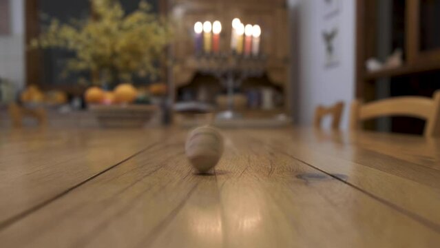 Jewish Dreidel or Sevivon spinning with Hanukia in the background. Hanukah holiday with jewish tradition 