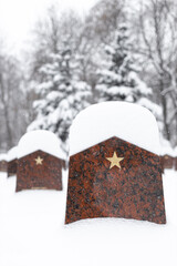 Tombstone in a military cemetery covered with snow.