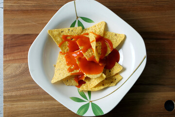 Plate with nachos and hot sauce