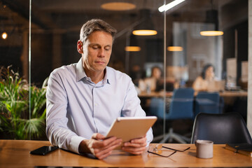 Portrait of businessman in office. Man using digital tablet. Businessman having video call.